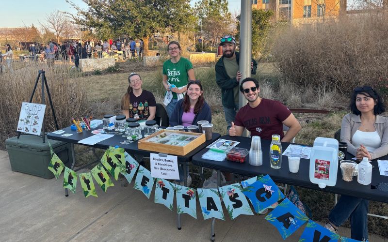 graduate students in booth outside